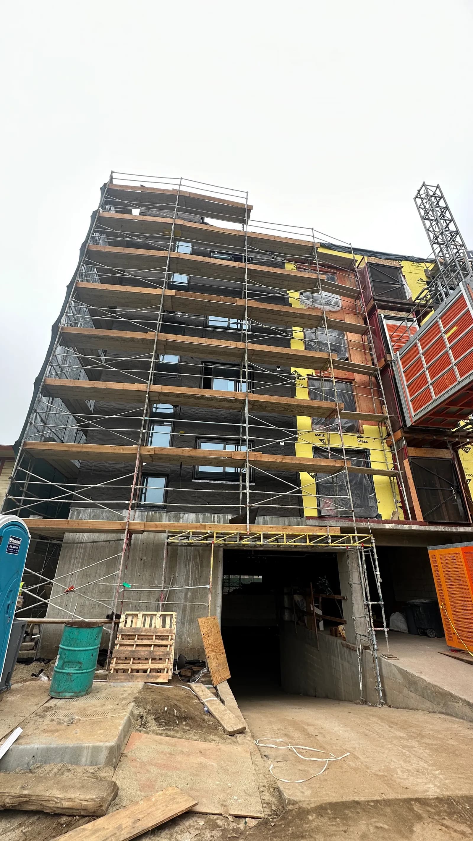 The same apartment building from the street, scaffolding running the full height.